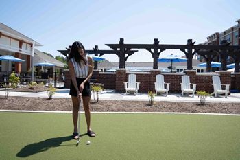 A Woman is Playing Mini Golf at The Aster Apartments, North Carolina